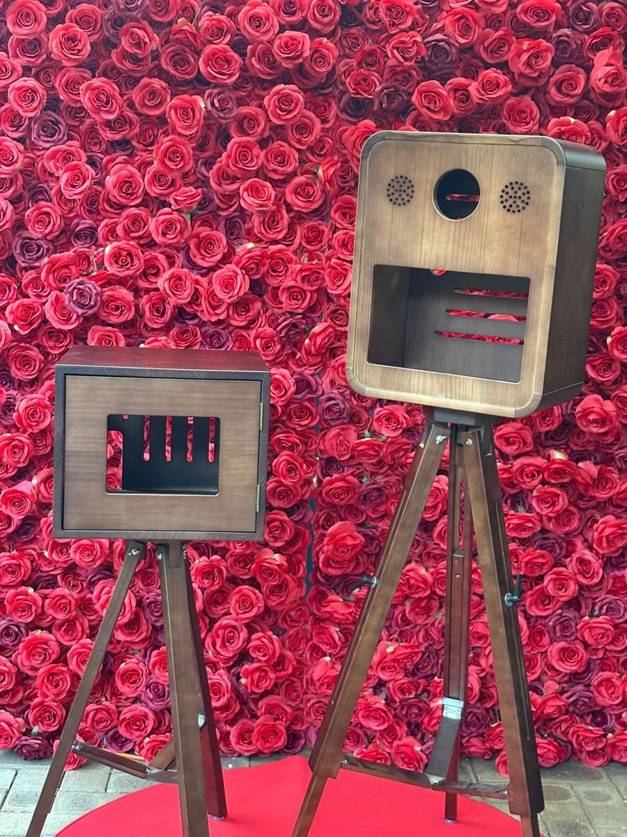 The Glamorous DSLR photo booth with a red rose wall, red carpet and gold bollards